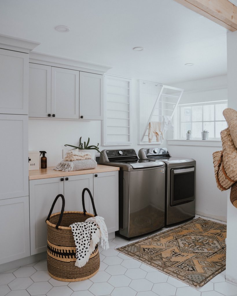 The Wild Decoelis | Laundry room makeover with grey cabinets, hexagon white tile and butcher block countertops