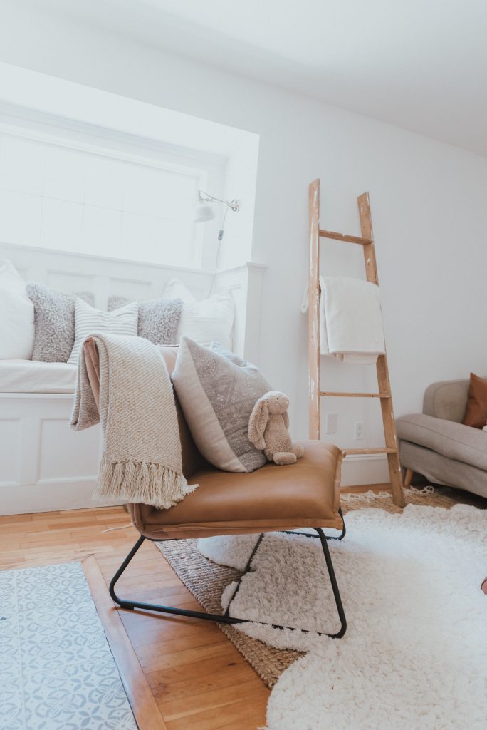 The Wild Decoelis | Our Cozy and Welcoming Family room | grey sectional, jute rug, shag sheepskin rug, leather ottoman, leather Mobilia ned chair, blanket ladder. window seat