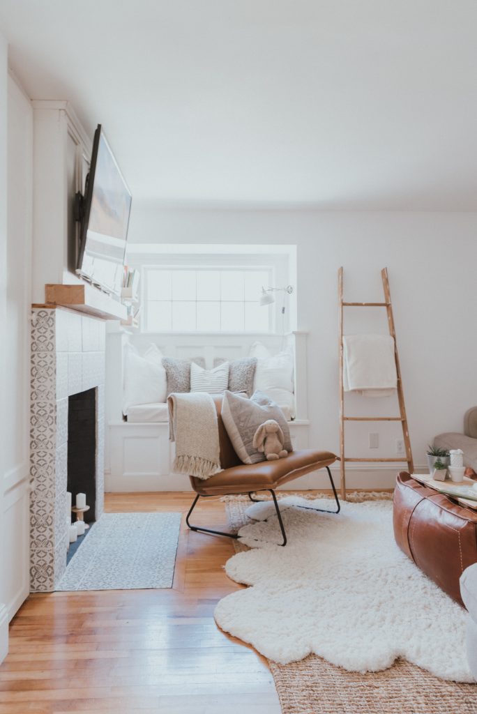The Wild Decoelis | Our Cozy and Welcoming Family room | grey sectional, jute rug, shag sheepskin rug, leather ottoman, leather Mobilia ned chair, blanket ladder.