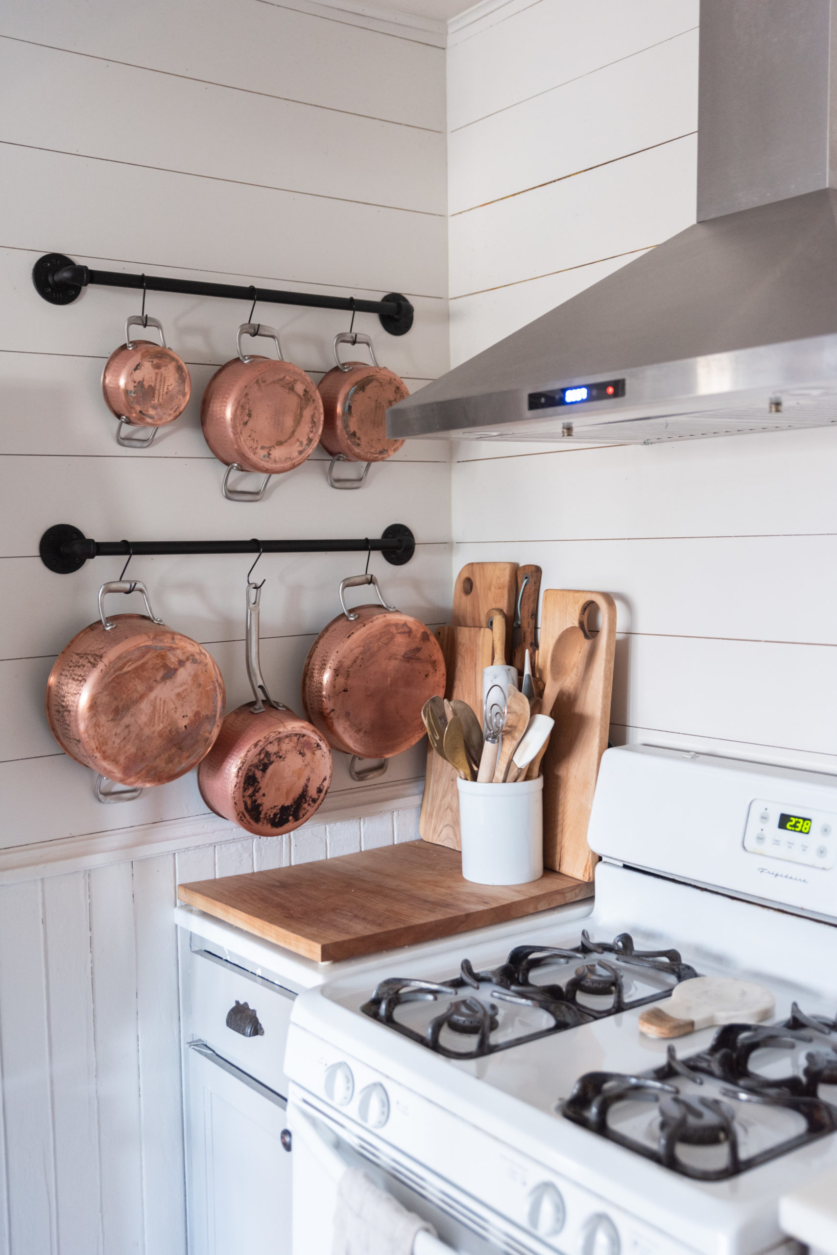 The Wild Decoelis | Our Lagostina Copper Pots: One year later How we feel about them | DIY Wall Pot Rack made of black pipe on shiplap wall in kitchen with marble countertops